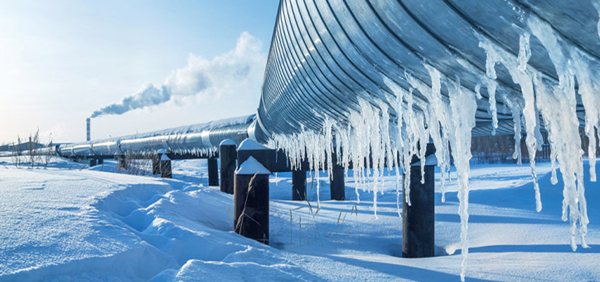 Gas pipes covered in ice with snow around
